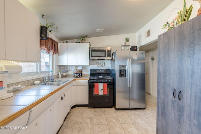 615 W 6th Ave, San Manuel, AZ 85631 - kitchen featuring appliances with stainless steel finishes, tile counters, a sink, and white cabinetry