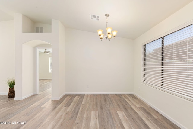 12356 N Globe Mallow Pl, Marana, AZ 85658 - empty room featuring a chandelier, light wood-type flooring, a ceiling fan, and arched walkways