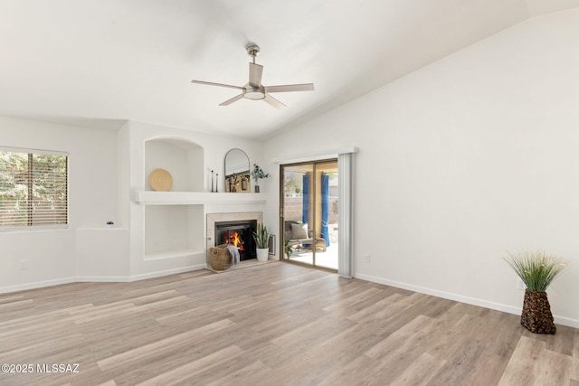 12356 N Globe Mallow Pl, Marana, AZ 85658 - unfurnished living room featuring lofted ceiling, ceiling fan, light wood-style floors, and a fireplace