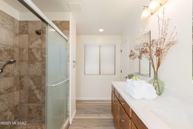 12356 N Globe Mallow Pl, Marana, AZ 85658 - bathroom with double vanity, a stall shower, wood finished floors, and recessed lighting