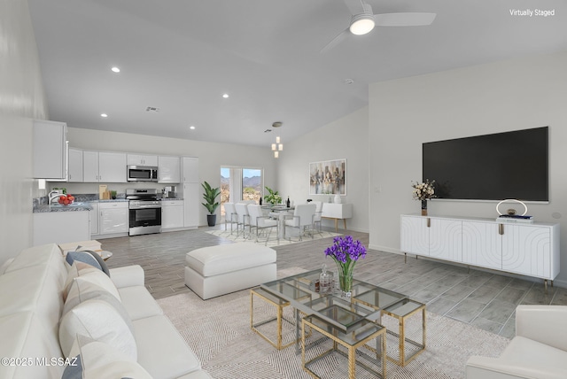 1895 Roma Ct, Rio Rico, AZ 85648 - living area featuring light wood finished floors, ceiling fan, high vaulted ceiling, recessed lighting, and baseboards