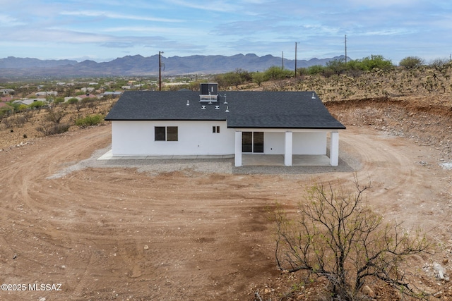 1895 Roma Ct, Rio Rico, AZ 85648 - view of front of property featuring a mountain view, a patio, stucco siding, and central AC unit