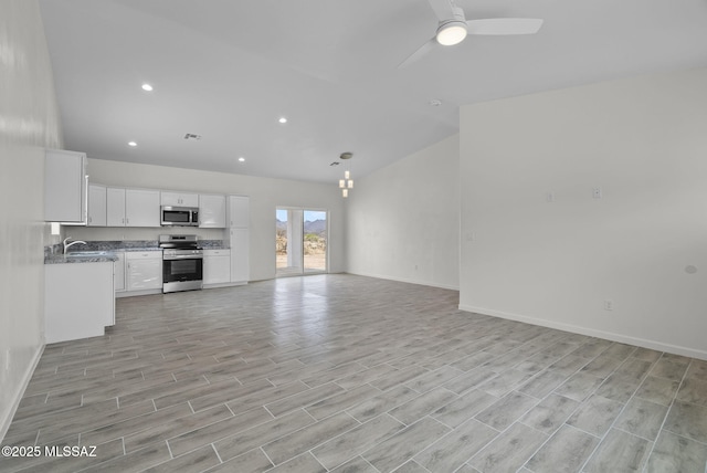 1895 Roma Ct, Rio Rico, AZ 85648 - unfurnished living room featuring a ceiling fan, baseboards, light wood-style flooring, recessed lighting, and a sink