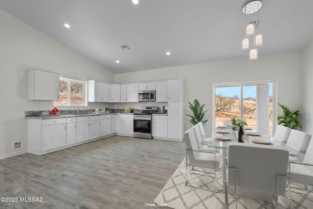 1895 Roma Ct, Rio Rico, AZ 85648 - kitchen with stainless steel appliances, healthy amount of natural light, lofted ceiling, white cabinets, and recessed lighting