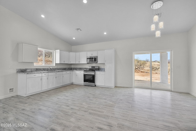 1895 Roma Ct, Rio Rico, AZ 85648 - kitchen featuring stainless steel appliances, baseboards, white cabinets, recessed lighting, and hanging light fixtures