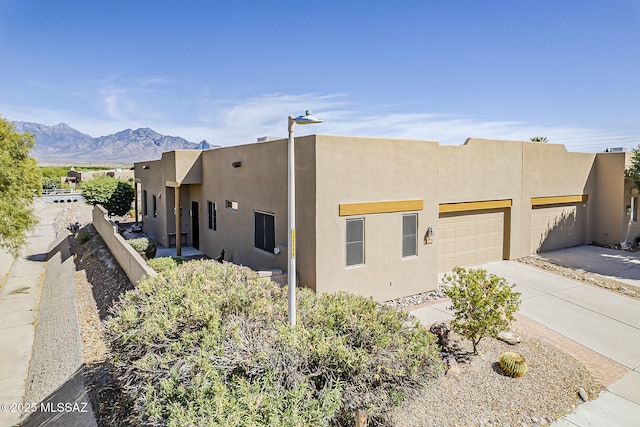 4043 S Golden Lynx Rd, Green Valley, AZ 85614 - view of front facade featuring driveway, stucco siding, an attached garage, and a mountain view