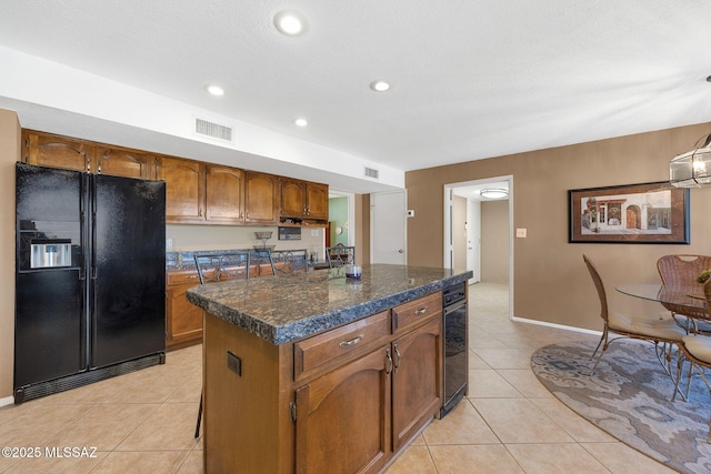 571 N Tanque Verde Loop Rd, Tucson, AZ 85748 - kitchen featuring black fridge, light tile patterned floors, brown cabinets, a kitchen island, and recessed lighting
