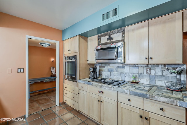 241 W Calle Mccleary, Green Valley, AZ 85614 - kitchen with appliances with stainless steel finishes, decorative backsplash, tile patterned flooring, and light brown cabinets