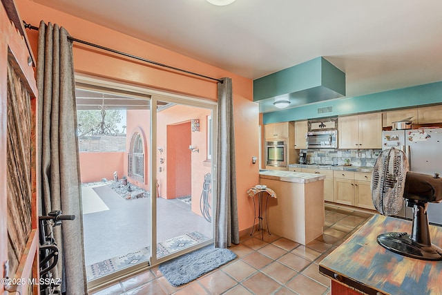 241 W Calle Mccleary, Green Valley, AZ 85614 - kitchen with appliances with stainless steel finishes, light brown cabinets, backsplash, light tile patterned floors, and light countertops