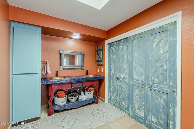 241 W Calle Mccleary, Green Valley, AZ 85614 - bathroom featuring tile patterned floors, double vanity, and a skylight