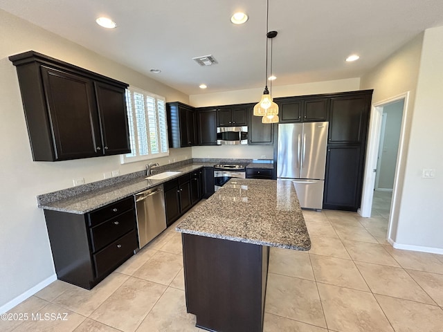 60422 E Arroyo Vista Dr, Oracle, AZ 85623 - kitchen featuring stainless steel appliances, a sink, stone counters, a center island, and baseboards