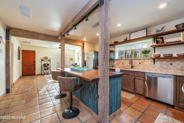 2120 N Fair Oaks Ave, Tucson, AZ 85712 - kitchen with appliances with stainless steel finishes, butcher block countertops, open shelves, decorative backsplash, and recessed lighting