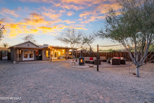 2120 N Fair Oaks Ave, Tucson, AZ 85712 - back of house at dusk with french doors, an outdoor living space with a fire pit, and a patio