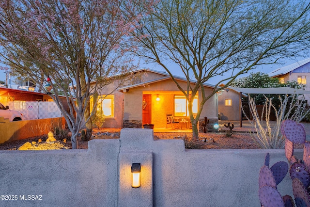2120 N Fair Oaks Ave, Tucson, AZ 85712 - view of front of property featuring a fenced front yard, stucco siding, covered porch, and an outdoor fire pit