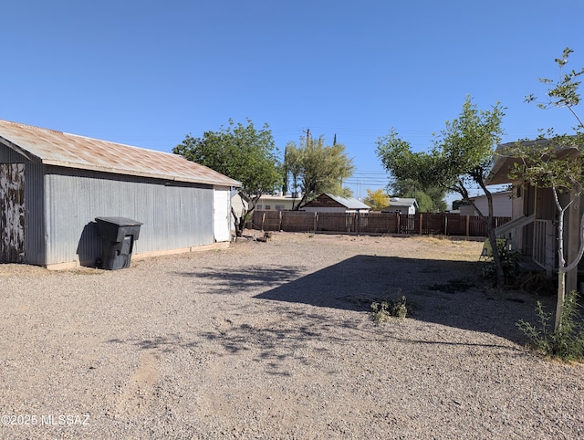 view of yard with fence and an outdoor structure