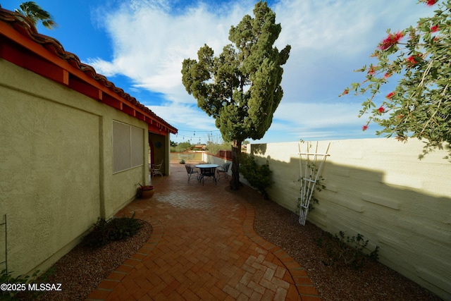980 W Camino Sagasta, Green Valley, AZ 85622 - view of side of home featuring stucco siding, a patio area, a fenced backyard, and outdoor dining space