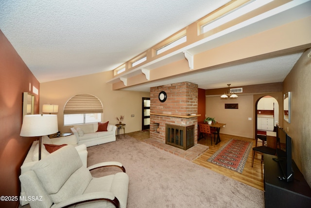 980 W Camino Sagasta, Green Valley, AZ 85622 - living area featuring a fireplace, wood finished floors, arched walkways, and a textured ceiling