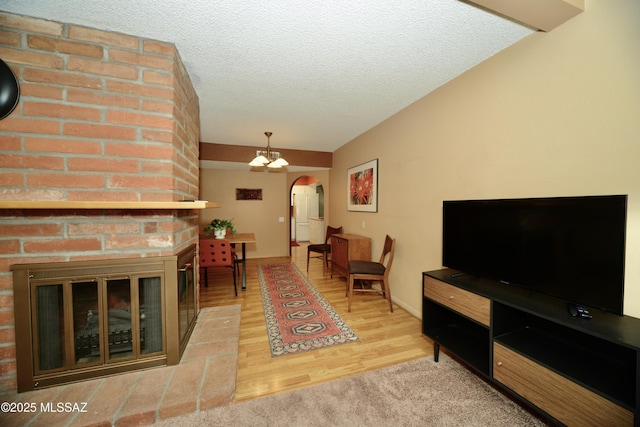 980 W Camino Sagasta, Green Valley, AZ 85622 - living room with arched walkways, wood finished floors, a textured ceiling, and lofted ceiling