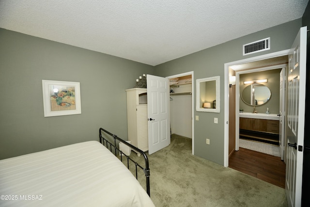 980 W Camino Sagasta, Green Valley, AZ 85622 - bedroom with carpet floors, a walk in closet, a textured ceiling, and a closet