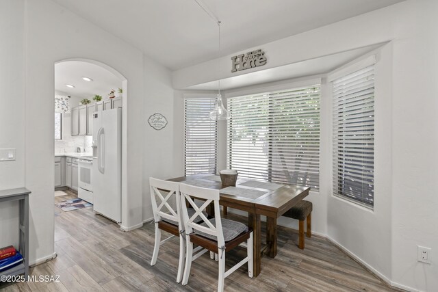 519 W Silvertip Rd, Tucson, AZ 85737 - dining area featuring light wood-style flooring, arched walkways, and baseboards