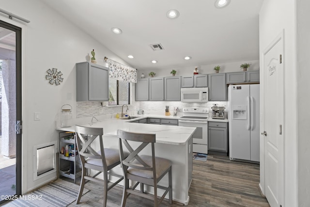 519 W Silvertip Rd, Tucson, AZ 85737 - kitchen with white appliances, gray cabinets, a sink, a peninsula, and backsplash