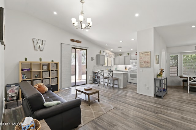 519 W Silvertip Rd, Tucson, AZ 85737 - living room featuring lofted ceiling, a chandelier, light wood-style floors, and recessed lighting