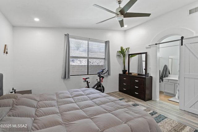 519 W Silvertip Rd, Tucson, AZ 85737 - bedroom with a barn door, light wood finished floors, recessed lighting, ensuite bath, and a ceiling fan