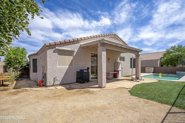 519 W Silvertip Rd, Tucson, AZ 85737 - back of property featuring a tile roof, stucco siding, a patio area, and a fenced backyard
