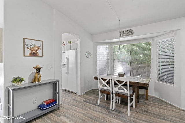 519 W Silvertip Rd, Tucson, AZ 85737 - dining space with arched walkways, light wood finished floors, vaulted ceiling, and baseboards