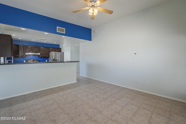 unfurnished living room featuring ceiling fan, baseboards, and light flooring