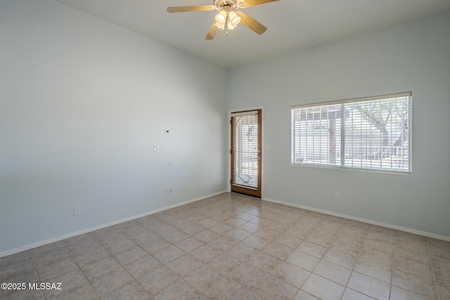 unfurnished room with ceiling fan, baseboards, and light tile patterned flooring