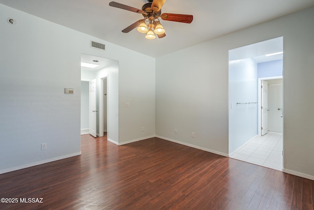 empty room with a ceiling fan, wood finished floors, and baseboards