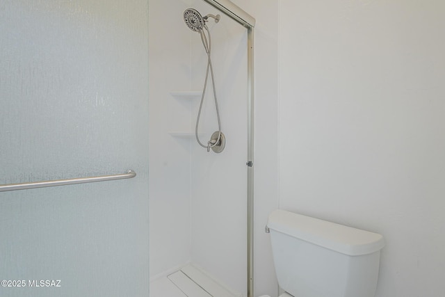 full bath featuring a shower stall and toilet