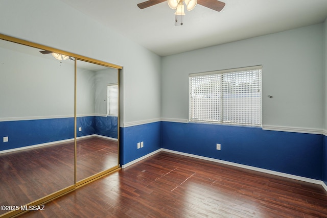 unfurnished room with a ceiling fan, wood finished floors, and baseboards