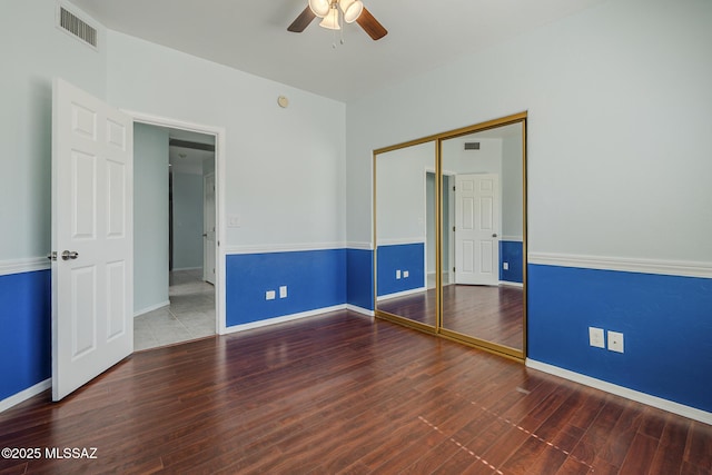 empty room featuring a ceiling fan, wood finished floors, and baseboards