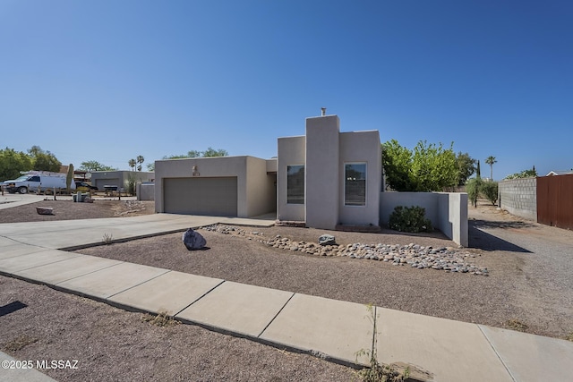 southwest-style home featuring stucco siding, an attached garage, and concrete driveway