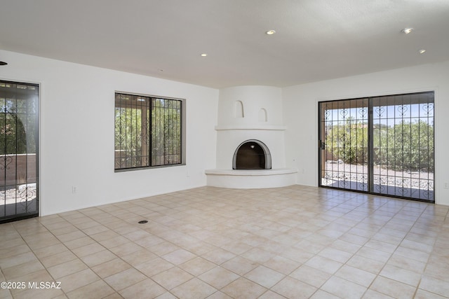 5790 E Chiricahua Trl, Tucson, AZ 85750 - unfurnished living room featuring a fireplace with raised hearth and recessed lighting