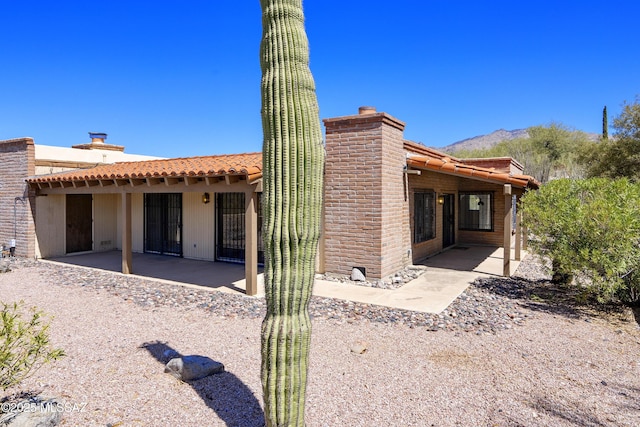 5790 E Chiricahua Trl, Tucson, AZ 85750 - rear view of house with a patio, a chimney, and a mountain view