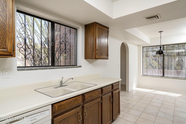5790 E Chiricahua Trl, Tucson, AZ 85750 - kitchen featuring a sink, dishwasher, arched walkways, light countertops, and pendant lighting