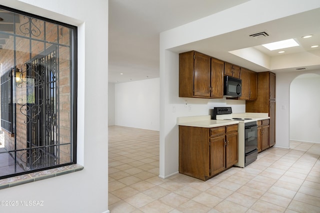 5790 E Chiricahua Trl, Tucson, AZ 85750 - kitchen with electric range oven, black microwave, arched walkways, light tile patterned floors, and light countertops