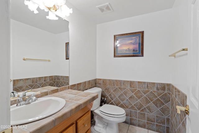 12220 E 5th St, Tucson, AZ 85748 - bathroom with toilet, tile walls, vanity, and wainscoting