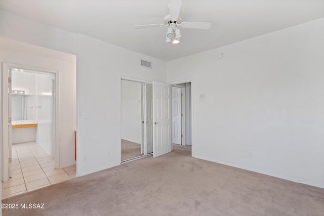 12220 E 5th St, Tucson, AZ 85748 - unfurnished bedroom with light carpet, a closet, a ceiling fan, light tile patterned flooring, and baseboards
