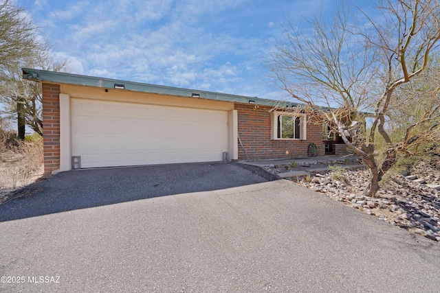 12220 E 5th St, Tucson, AZ 85748 - view of front of house with brick siding, driveway, and a garage