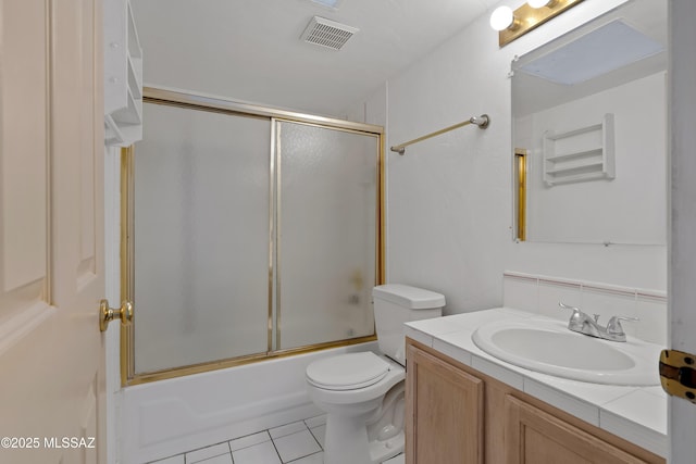 12220 E 5th St, Tucson, AZ 85748 - full bath with tile patterned flooring, toilet, vanity, decorative backsplash, and combined bath / shower with glass door