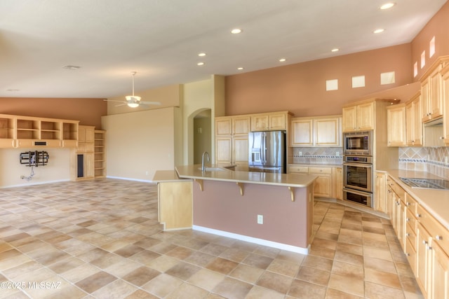 63063 E Mountain Crest Dr, Saddlebrooke, AZ 85739 - kitchen with stainless steel appliances, high vaulted ceiling, a kitchen island with sink, open floor plan, and ceiling fan