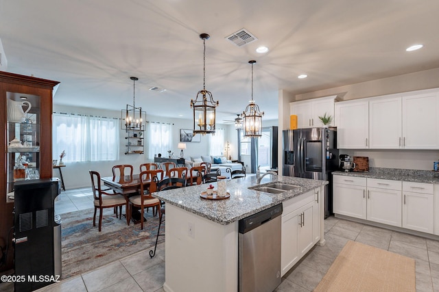 11267 S Weismann Dr, Vail, AZ 85641 - kitchen featuring appliances with stainless steel finishes, a sink, a chandelier, a center island with sink, and light stone counters