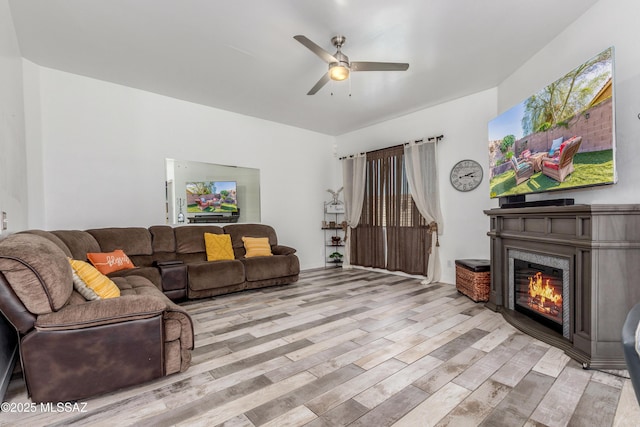 8434 N Sunny Rock Ridge Dr, Tucson, AZ 85743 - living room featuring a ceiling fan, light wood-type flooring, and a glass covered fireplace