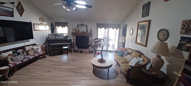 4081 N Hidden Cove Pl, Tucson, AZ 85749 - living room featuring lofted ceiling, ceiling fan, a fireplace, and wood finished floors
