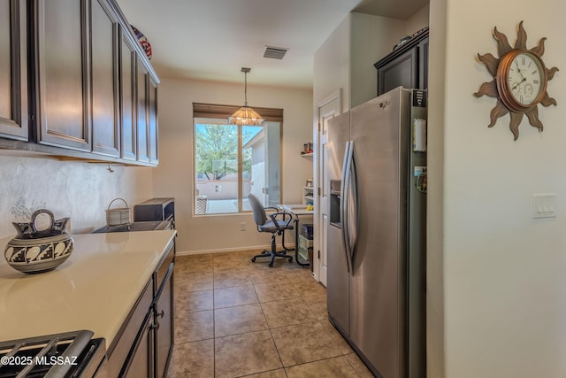 1104 W Pastora Peak Dr, Green Valley, AZ 85614 - kitchen with stainless steel fridge, an office area, decorative light fixtures, light countertops, and light tile patterned flooring