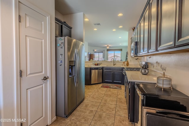 1104 W Pastora Peak Dr, Green Valley, AZ 85614 - kitchen with stainless steel appliances, a sink, light countertops, light tile patterned flooring, and recessed lighting